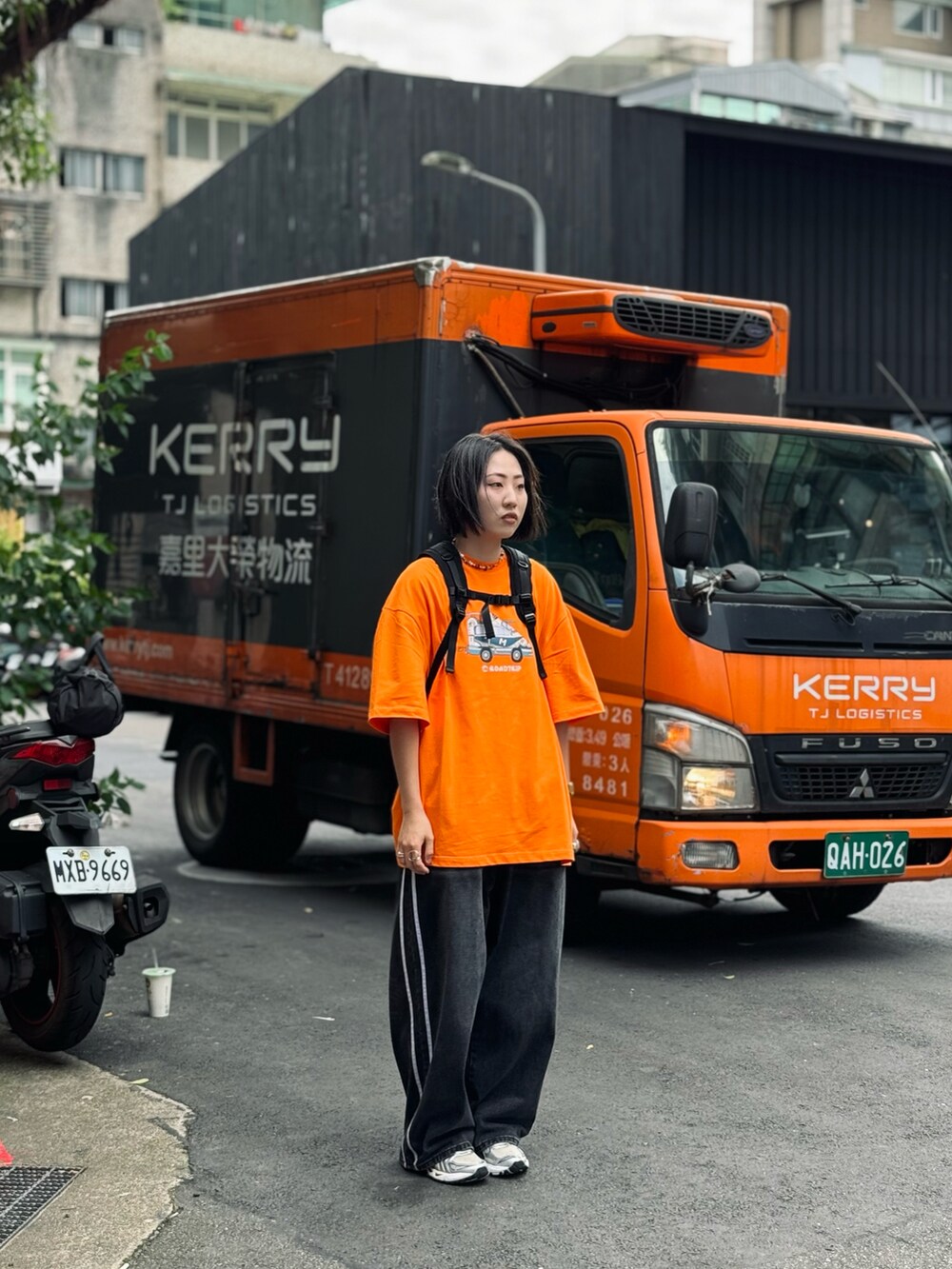 ブラック系のデニムパンツ、シルバー系のスニーカーを着用したレディースの夏コーディネートの2枚目の写真