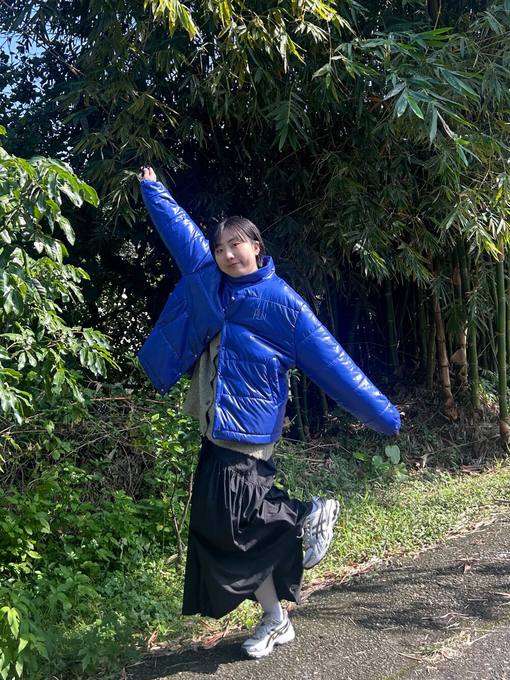 ブルー系のダウンジャケット/コート、ホワイト系のスカート、シルバー系のスニーカーを着用したレディースの冬コーディネートの2枚目の写真