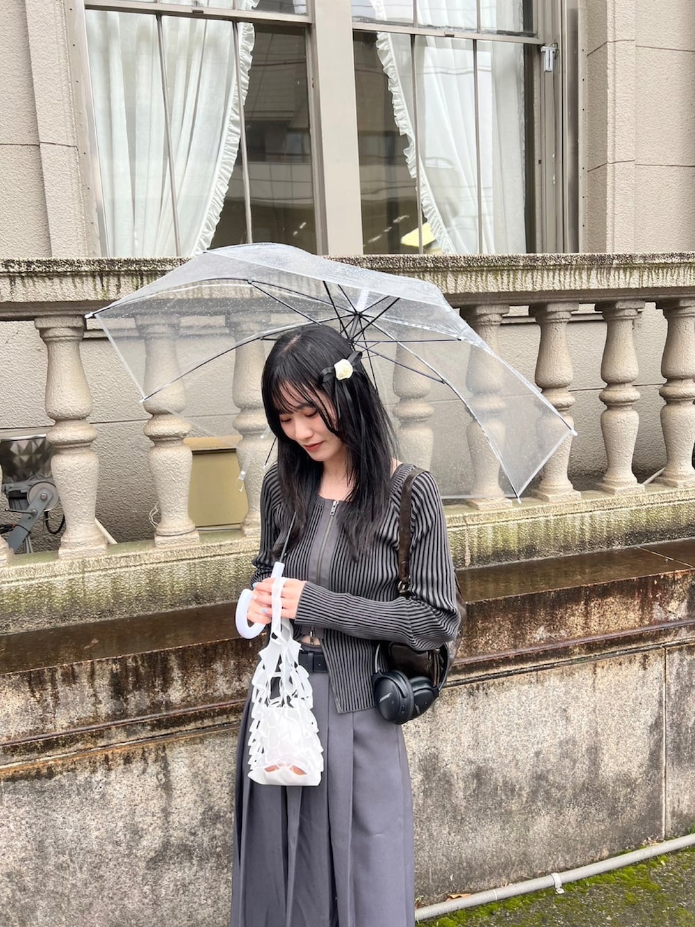 ブラック系のローファー、グレー系のスカート、ブラック系のニット/セーターを着用したレディースの春コーディネートの3枚目の写真