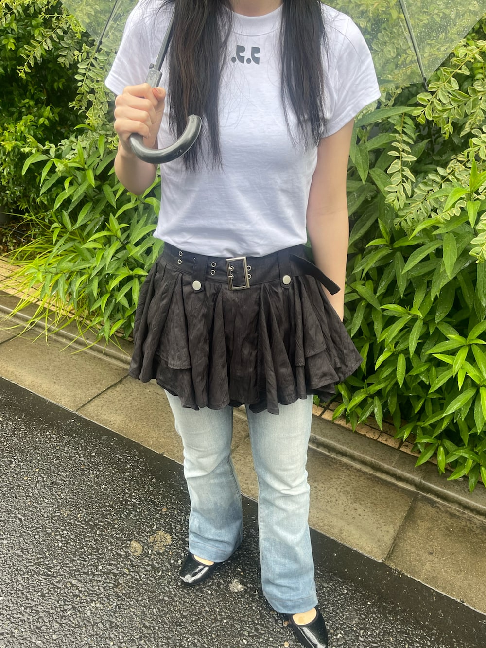 ブルー系のデニムパンツ、ブラック系のバレエシューズ、ブラック系のスカートを着用したレディースの夏コーディネートの2枚目の写真