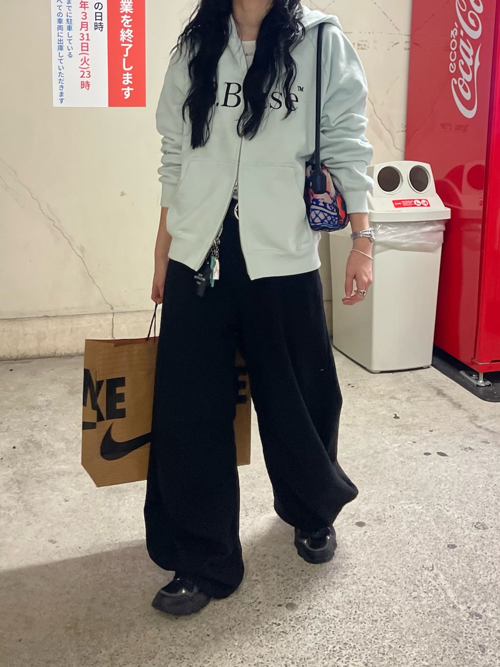 ブルー系のパーカー、ブラック系のスニーカー、ブラック系のデニムパンツを着用したレディースの冬コーディネートの3枚目の写真