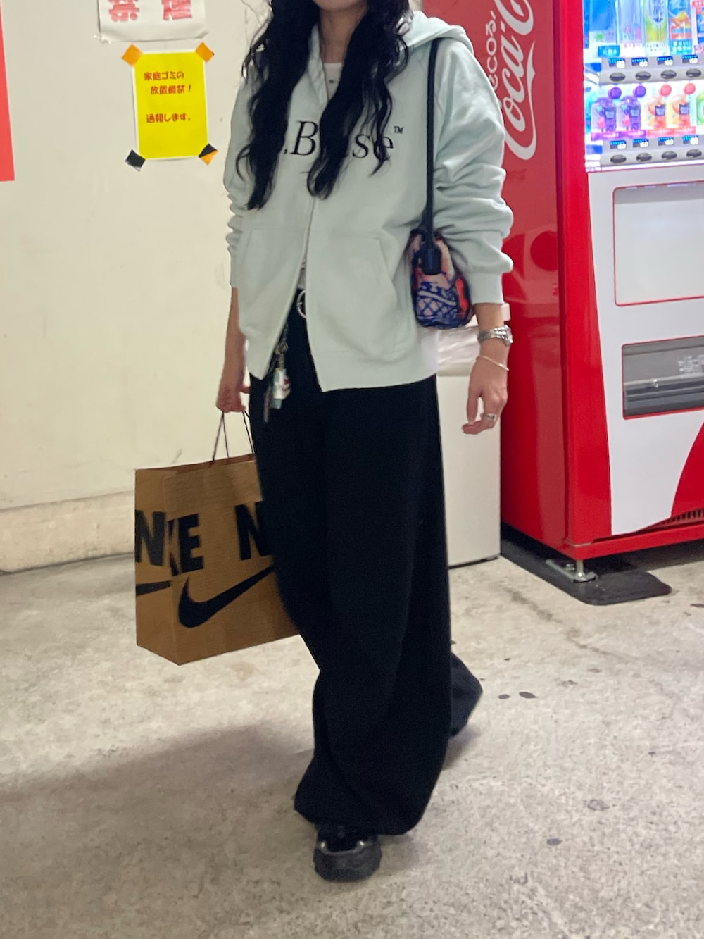 ブルー系のパーカー、ブラック系のスニーカー、ブラック系のデニムパンツを着用したレディースの冬コーディネートの2枚目の写真