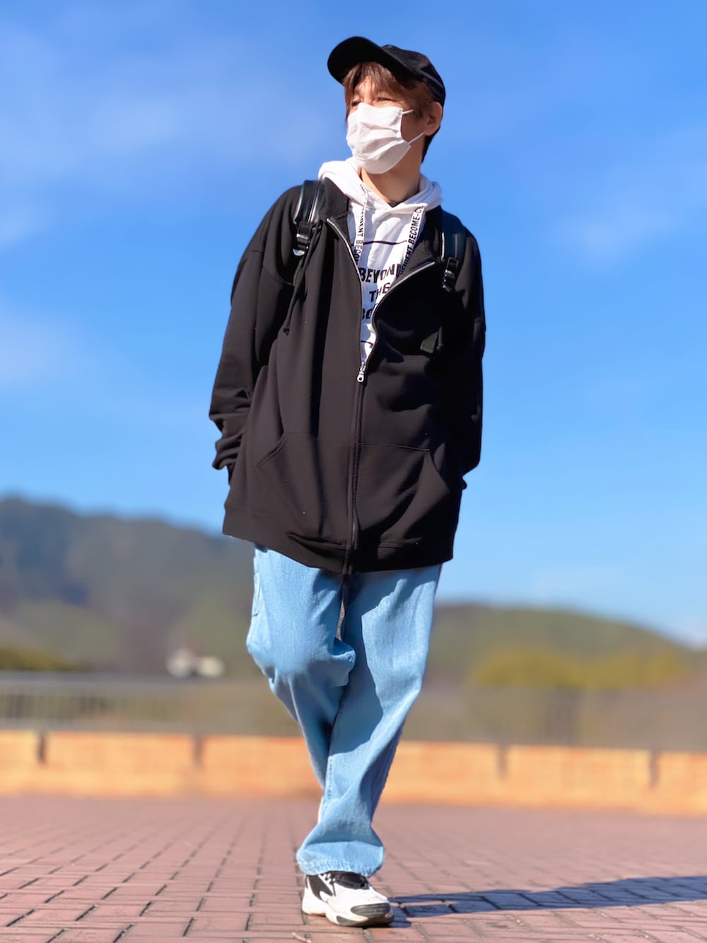 ブラック系のバックパック/リュック、ブラック系のパーカー、ホワイト系のパーカーを着用したメンズの冬コーディネートの2枚目の写真