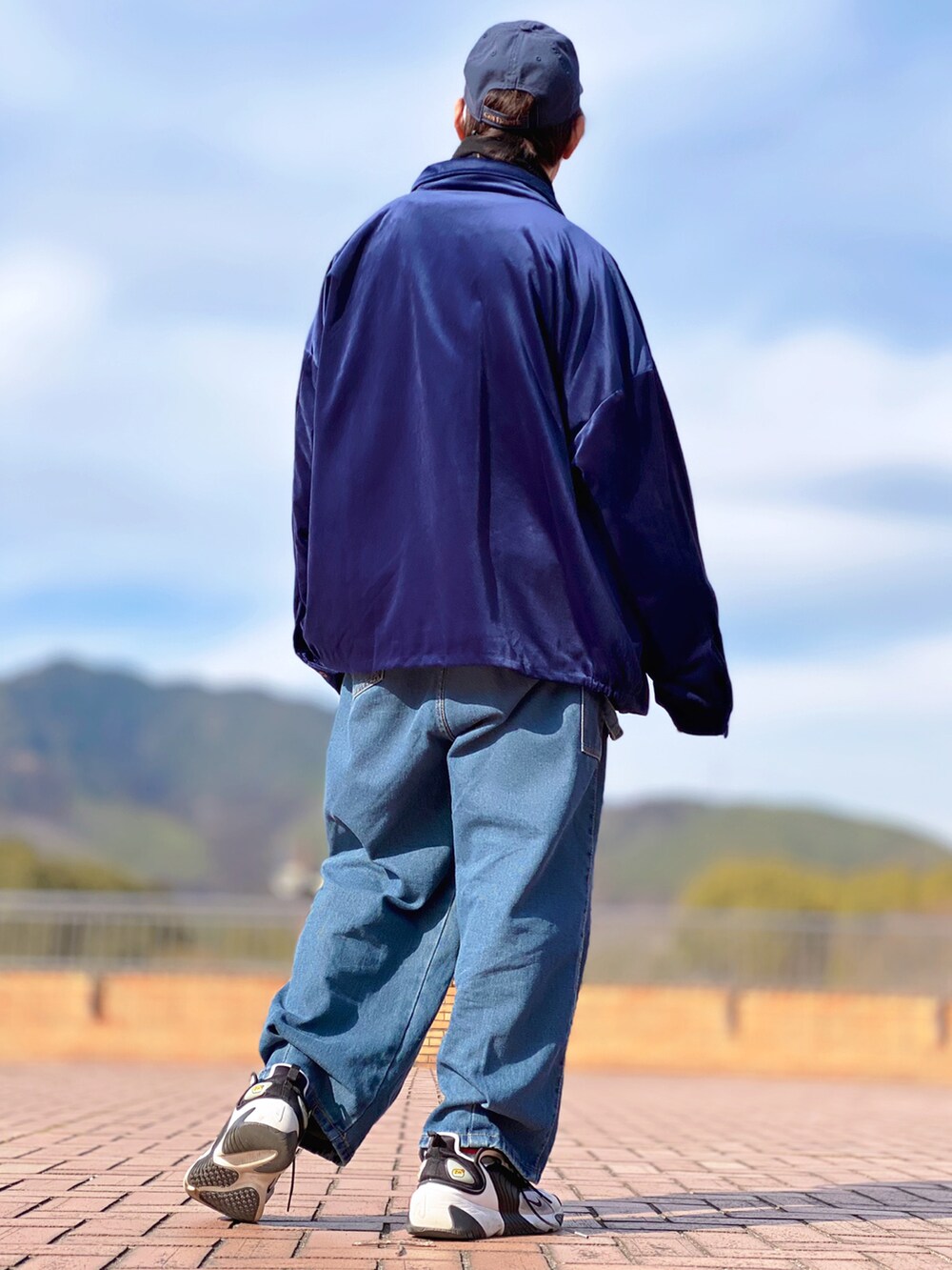 ブルー系のブルゾン、ブラック系のスウェット、ブルー系のデニムパンツを着用したメンズの春コーディネートの3枚目の写真