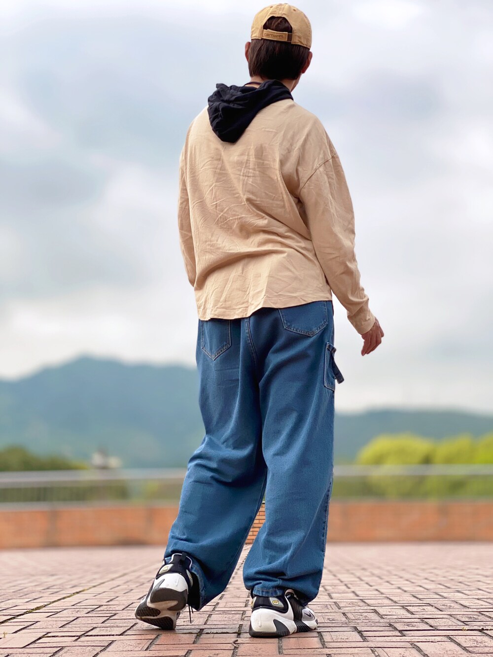 ベージュ系のパーカー、ブルー系のデニムパンツ、ホワイト系のスニーカーを着用したメンズの春コーディネートの3枚目の写真