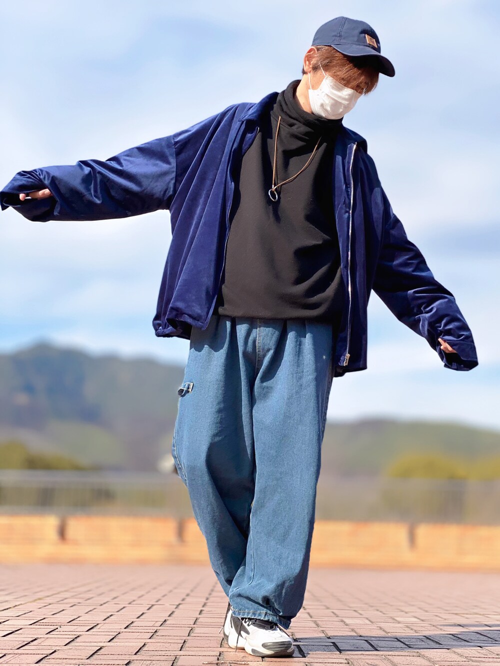 ブルー系のブルゾン、ブラック系のスウェット、ブルー系のデニムパンツを着用したメンズの春コーディネートの2枚目の写真