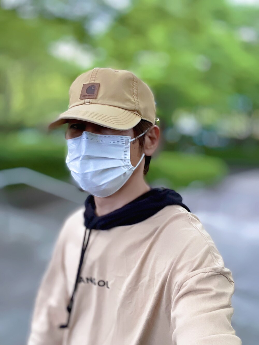 ベージュ系のパーカー、ブルー系のデニムパンツ、ホワイト系のスニーカーを着用したメンズの春コーディネートの4枚目の写真