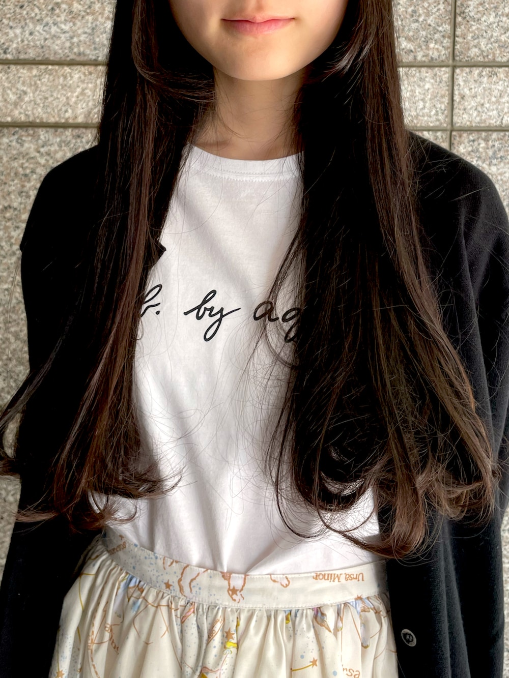 ホワイト系のTシャツ/カットソー、ホワイト系のスカート、ホワイト系のスニーカーを着用したレディースの春コーディネートの2枚目の写真