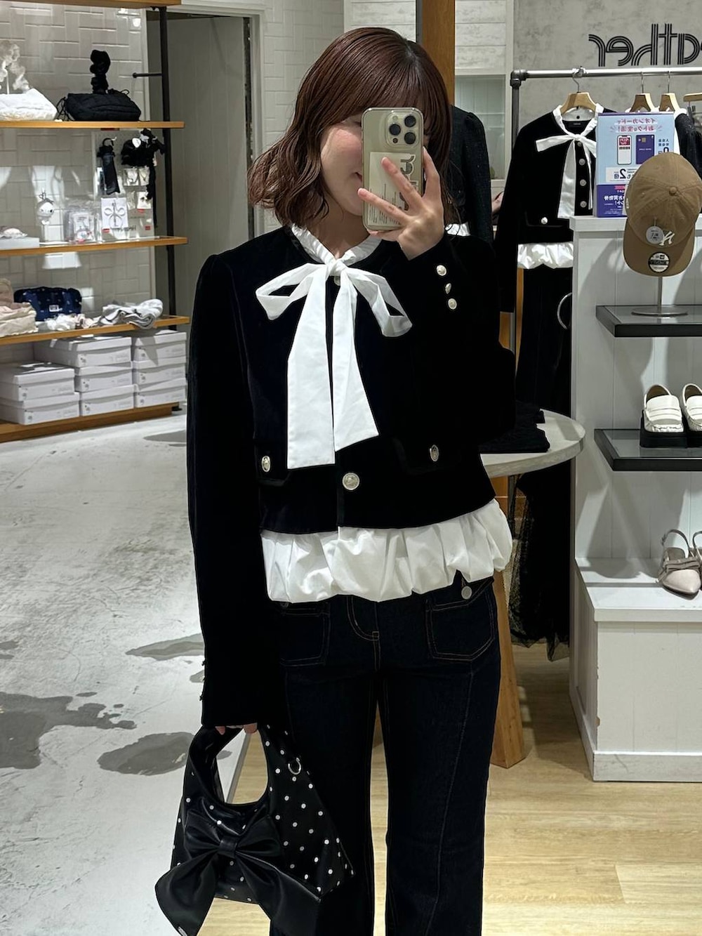 ブルー系のデニムパンツ、ブラック系のノーカラージャケット、ブラック系のパンプスを着用したレディースの秋コーディネートの2枚目の写真