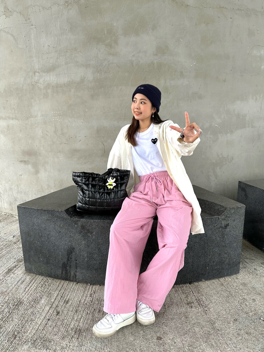 ホワイト系のTシャツ/カットソー、ピンク系のパンツ、ブラック系のトートバッグを着用したレディースの春コーディネートの2枚目の写真