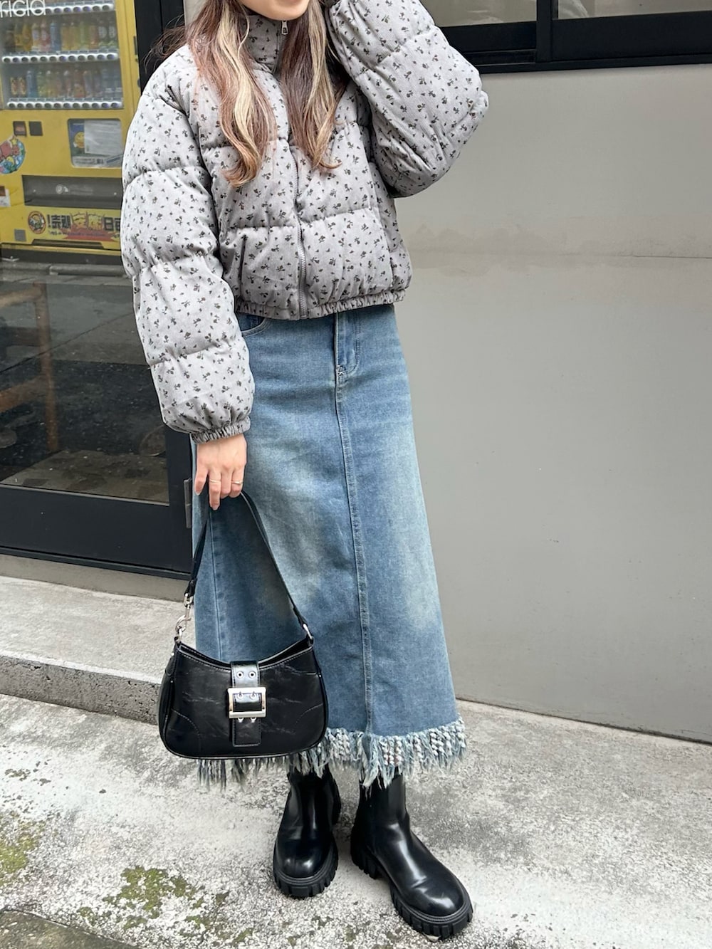 グレー系のダウンジャケット/コート、ブルー系のデニムスカート、ブラック系のニットキャップ/ビーニーを着用したレディースの秋コーディネートの2枚目の写真