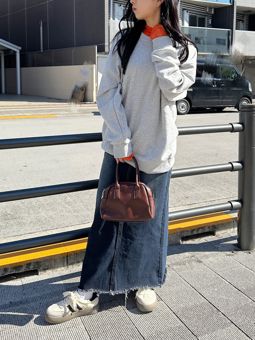 ブルー系のデニムスカート、オレンジ系のTシャツ/カットソーを着用したレディースの冬コーディネートの2枚目の写真