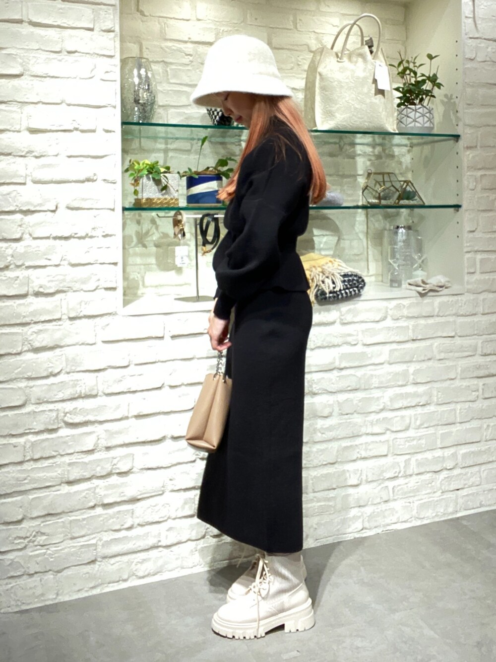 ブラック系のワンピース、ベージュ系のショルダーバッグ、ホワイト系のブーツを着用したレディースの秋コーディネートの3枚目の写真