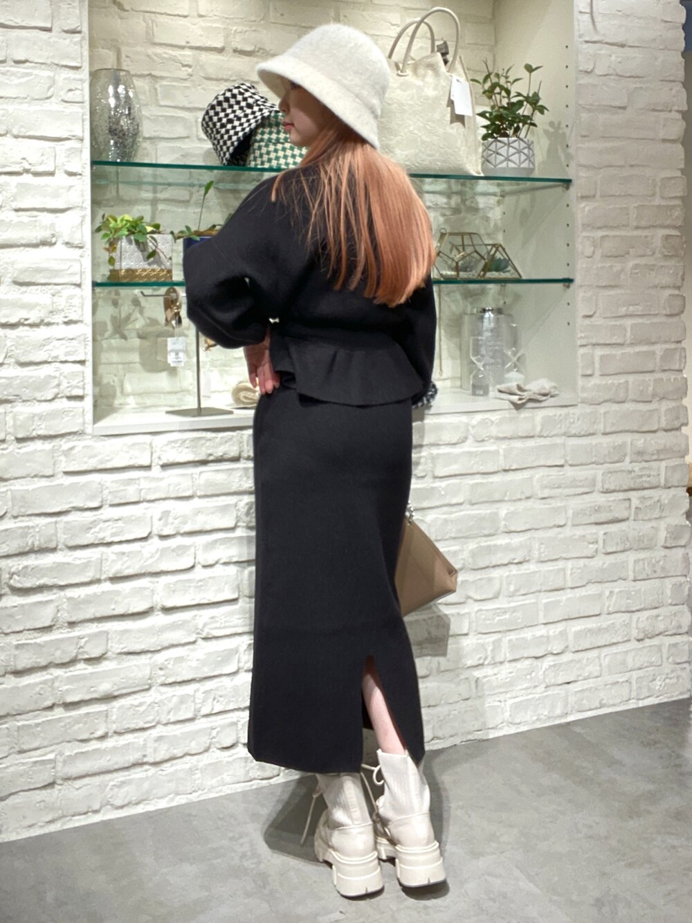 ブラック系のワンピース、ベージュ系のショルダーバッグ、ホワイト系のブーツを着用したレディースの秋コーディネートの4枚目の写真