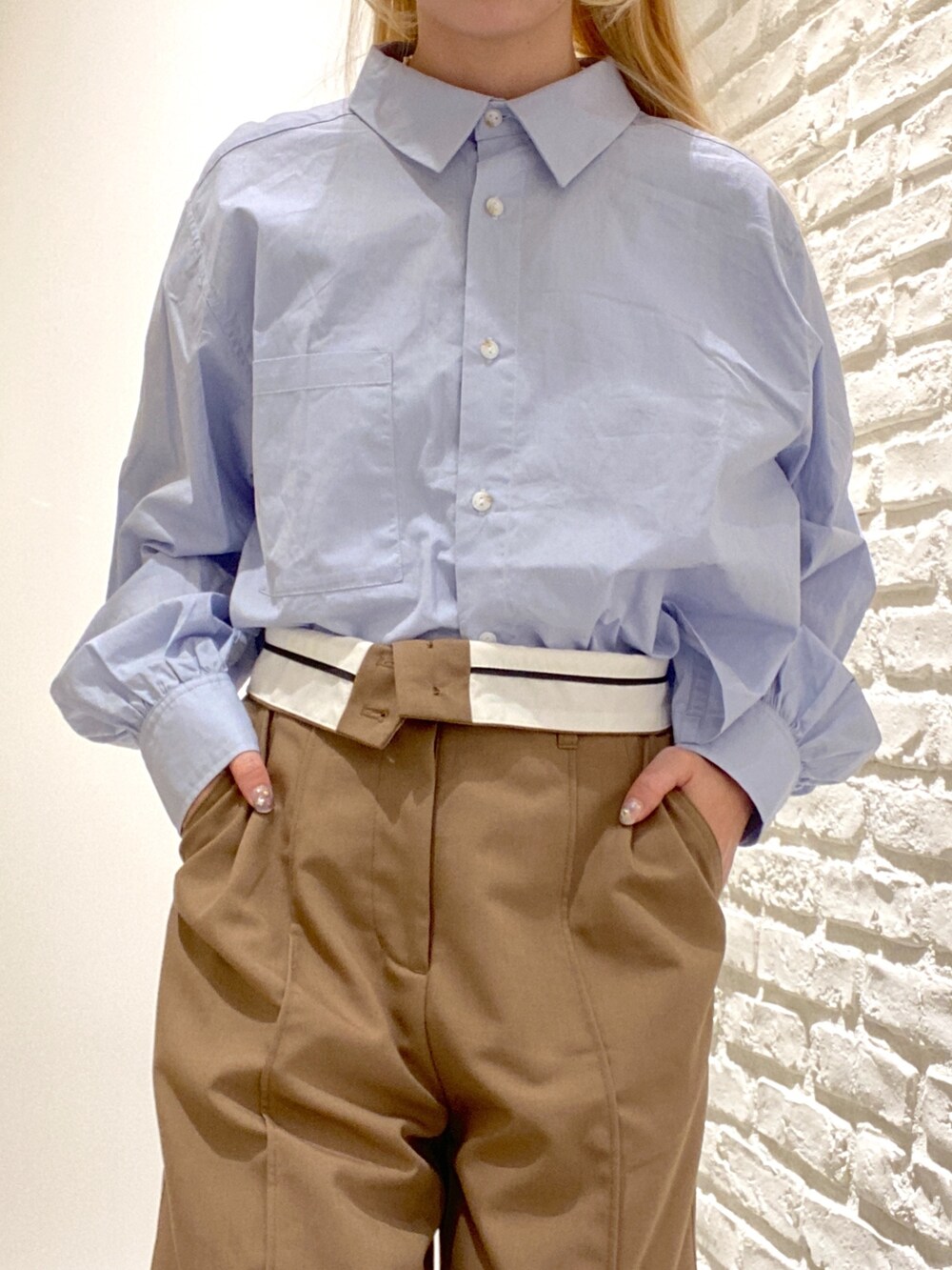 ベージュ系のスラックス、ブルー系のシャツ/ブラウス、ブラック系のブーツを着用したレディースの秋コーディネートの4枚目の写真