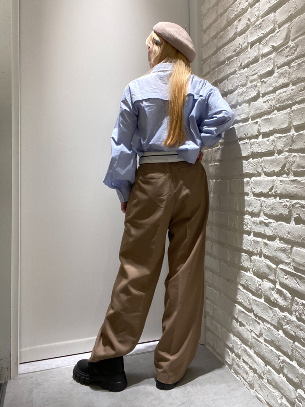 ベージュ系のスラックス、ブルー系のシャツ/ブラウス、ブラック系のブーツを着用したレディースの秋コーディネートの3枚目の写真