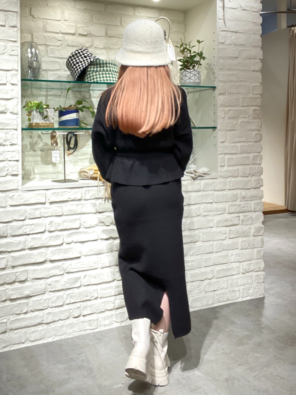 ブラック系のワンピース、ベージュ系のショルダーバッグ、ホワイト系のブーツを着用したレディースの秋コーディネートの5枚目の写真