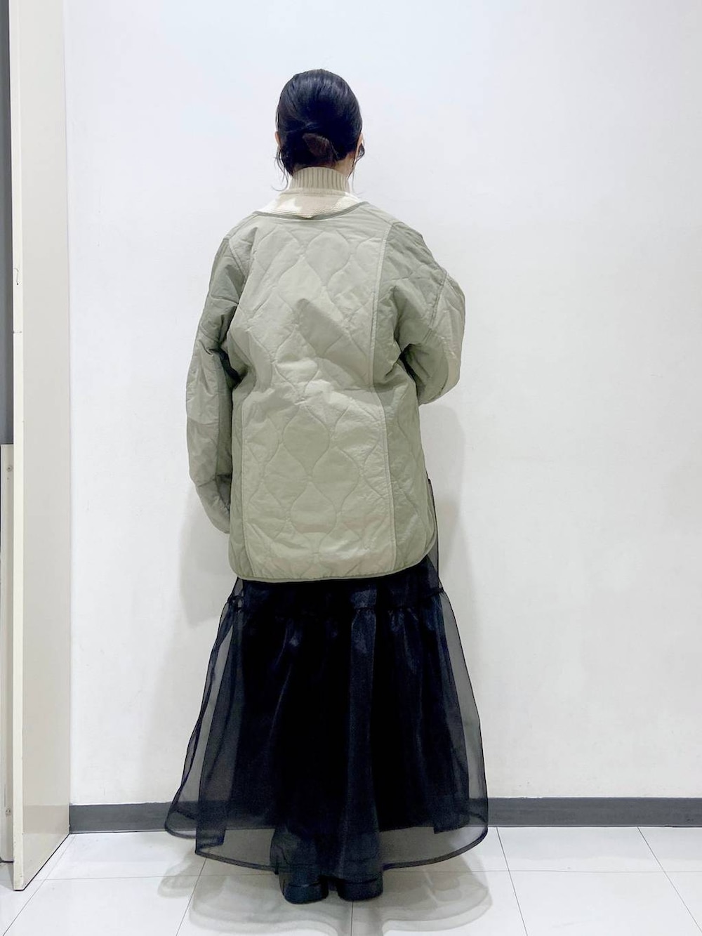 ホワイト系のニット/セーター、グリーン系のブルゾン、ホワイト系のショルダーバッグを着用したレディースの冬コーディネートの4枚目の写真