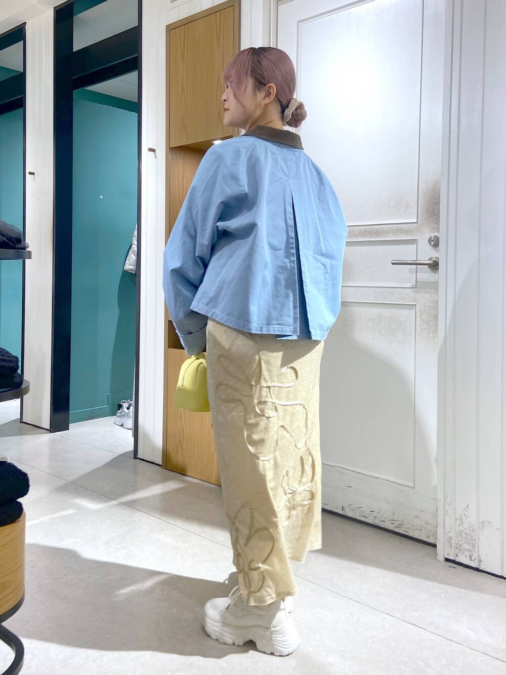 ホワイト系のTシャツ/カットソー、ブルー系のテーラードジャケット、ホワイト系のスニーカーを着用したレディースの秋コーディネートの4枚目の写真