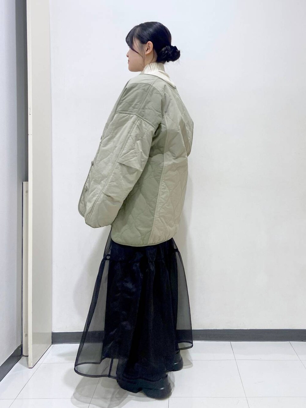 ホワイト系のニット/セーター、グリーン系のブルゾン、ホワイト系のショルダーバッグを着用したレディースの冬コーディネートの3枚目の写真