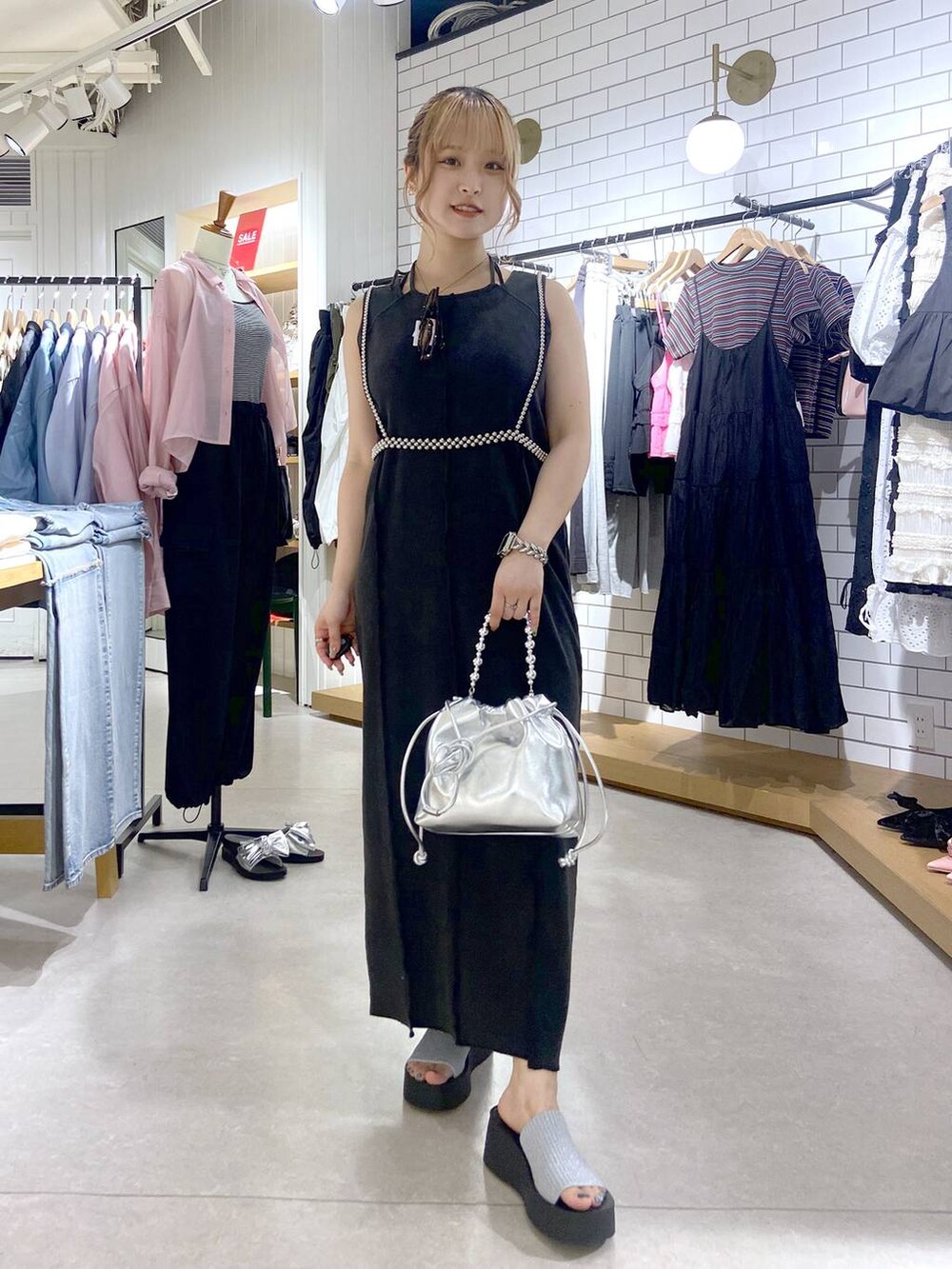 シルバー系のサンダル、シルバー系のショルダーバッグ、グレー系のワンピースを着用したレディースの夏コーディネートの3枚目の写真