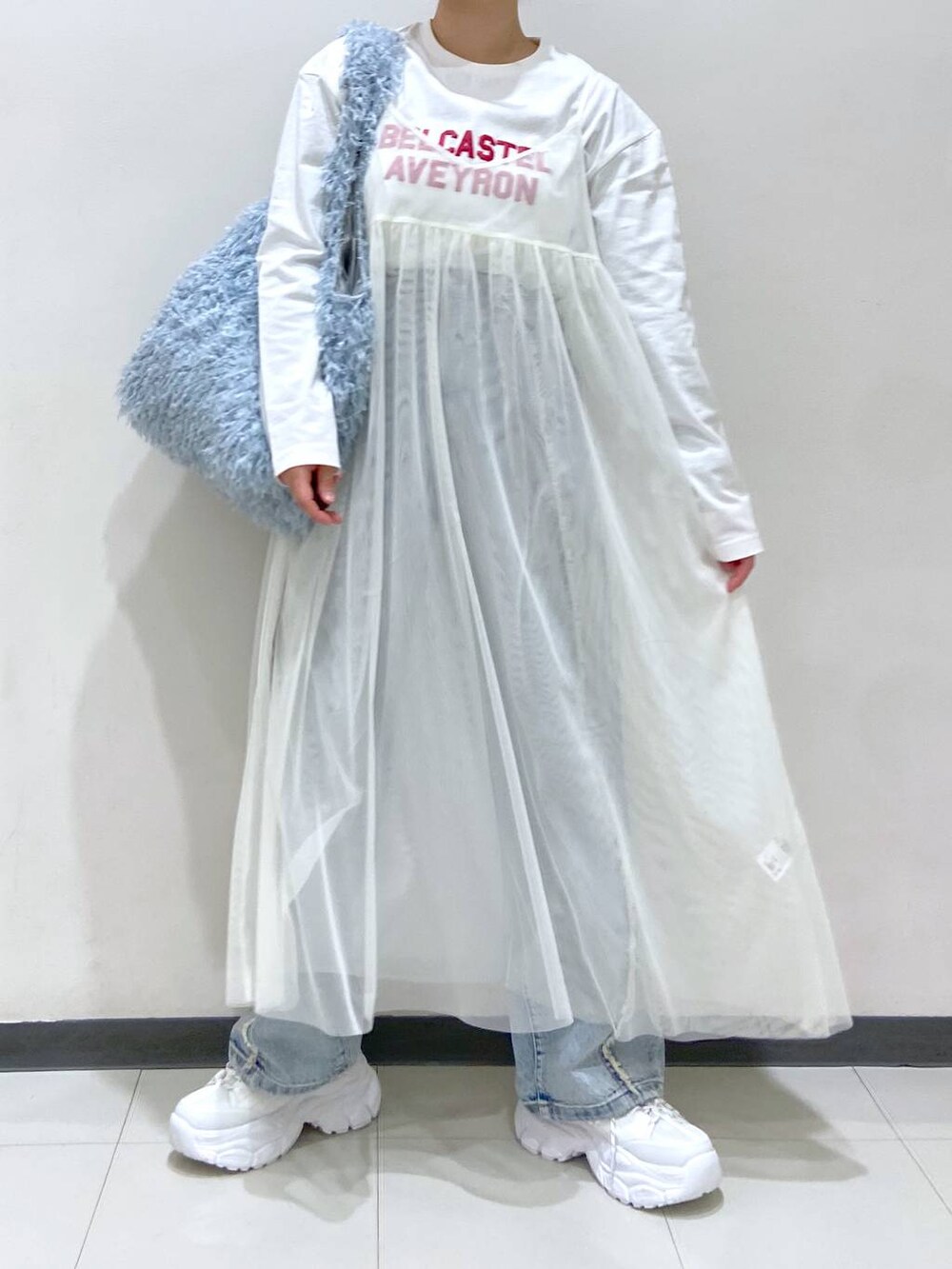 ホワイト系のワンピース、ホワイト系のTシャツ/カットソー、ブルー系のトートバッグを着用したレディースの冬コーディネートの3枚目の写真