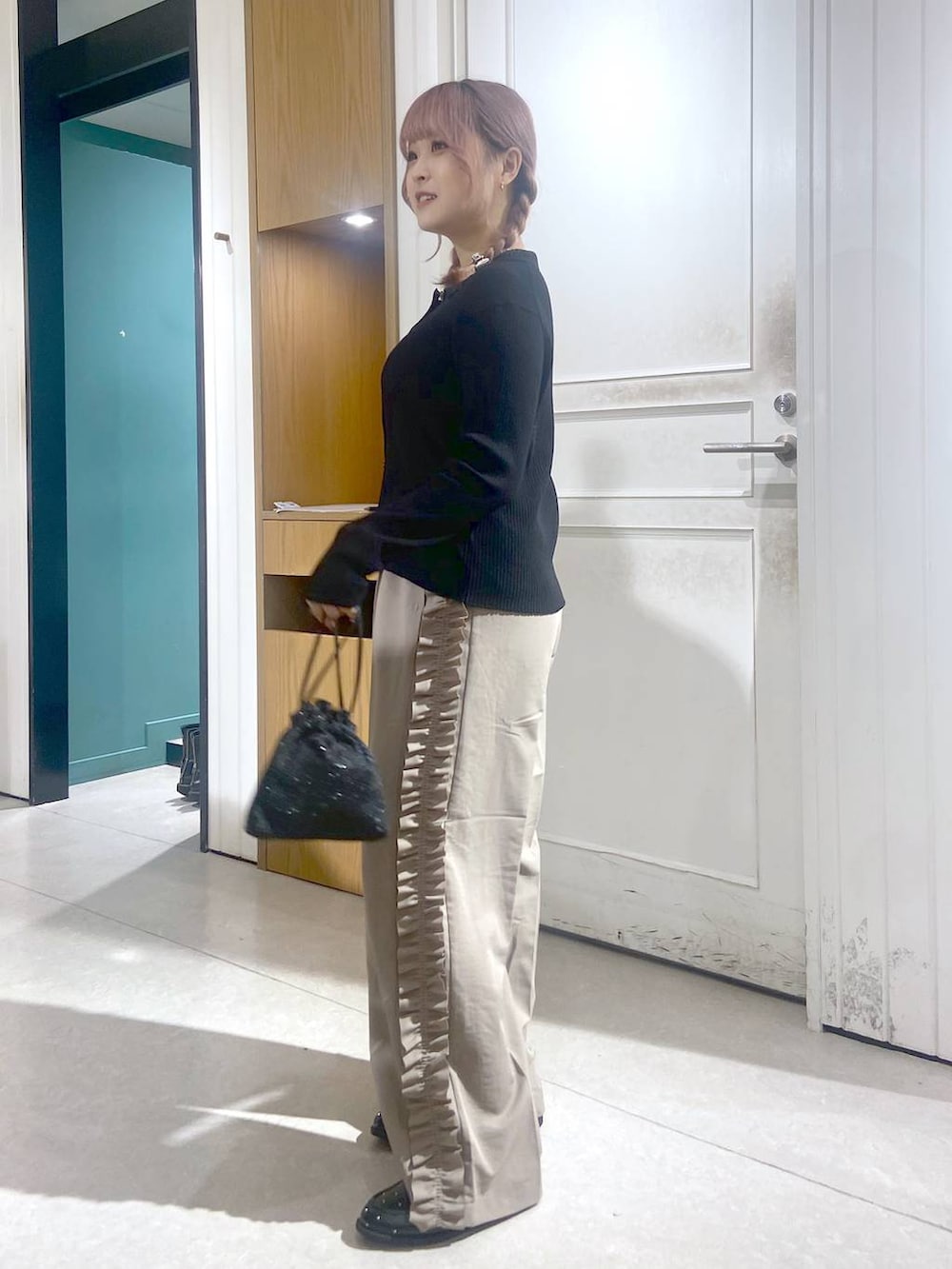 ブラック系のショルダーバッグ、ブラック系のローファー、ブラック系のニット/セーターを着用したレディースの秋コーディネートの6枚目の写真