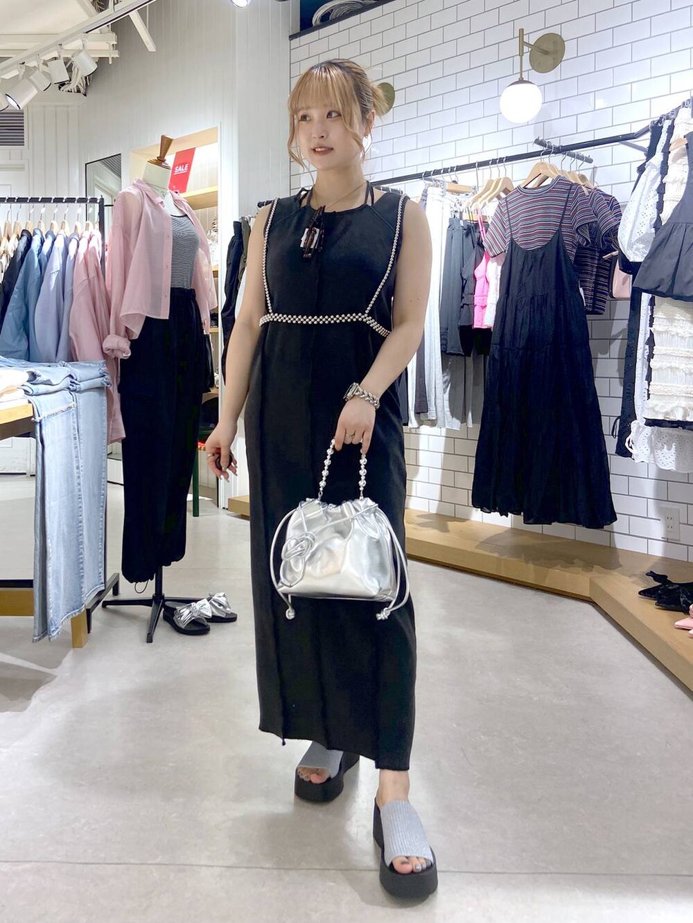 シルバー系のサンダル、シルバー系のショルダーバッグ、グレー系のワンピースを着用したレディースの夏コーディネートの2枚目の写真