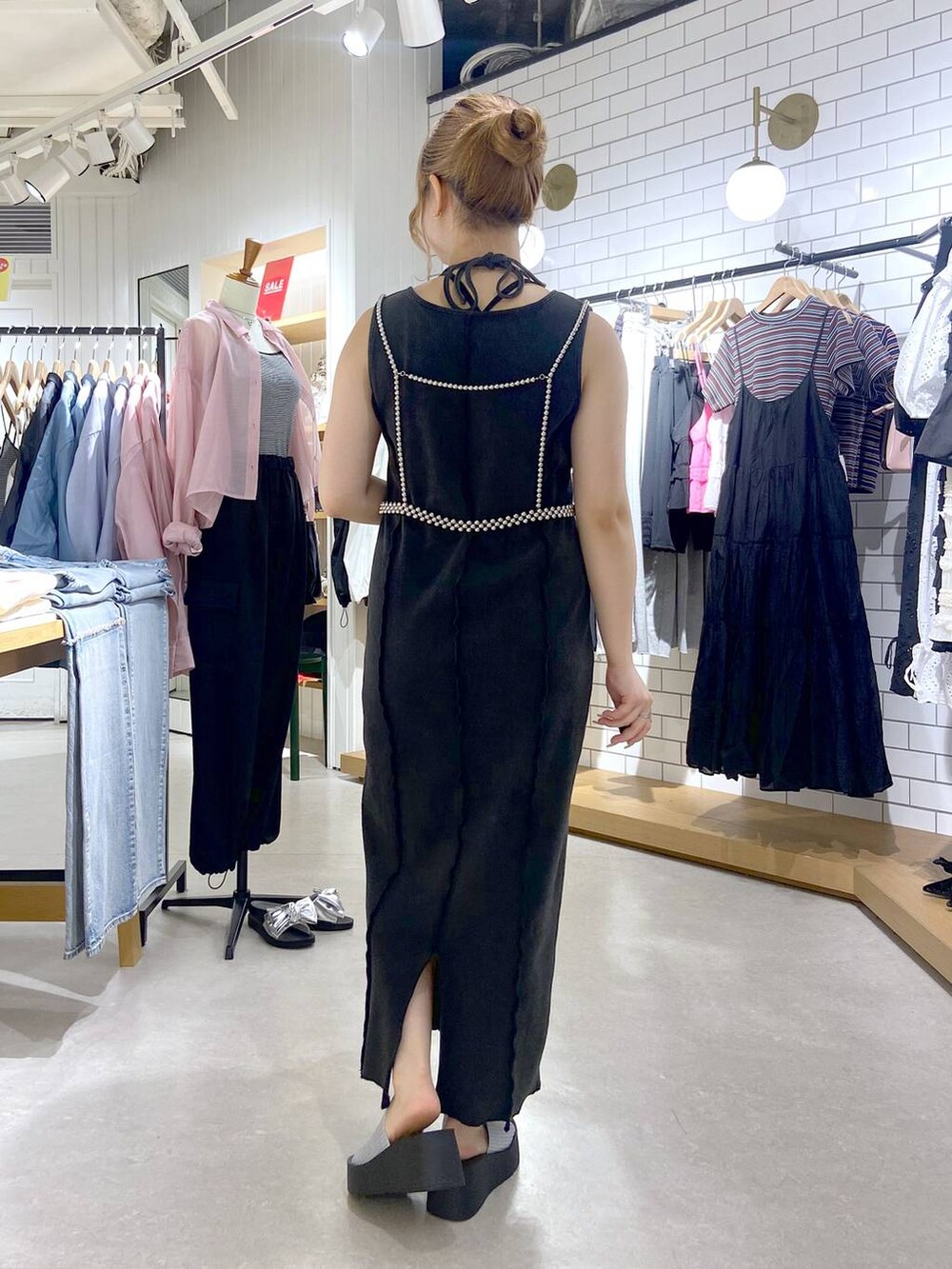 シルバー系のサンダル、シルバー系のショルダーバッグ、グレー系のワンピースを着用したレディースの夏コーディネートの5枚目の写真