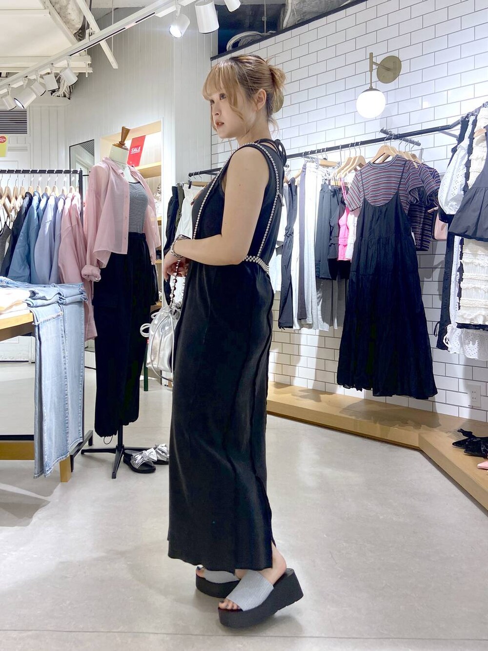 シルバー系のサンダル、シルバー系のショルダーバッグ、グレー系のワンピースを着用したレディースの夏コーディネートの4枚目の写真