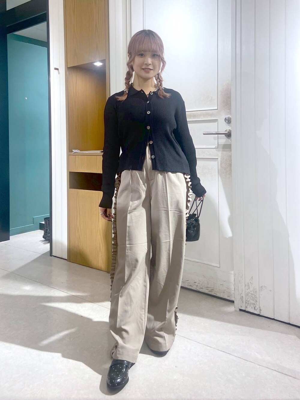 ブラック系のショルダーバッグ、ブラック系のローファー、ブラック系のニット/セーターを着用したレディースの秋コーディネートの3枚目の写真