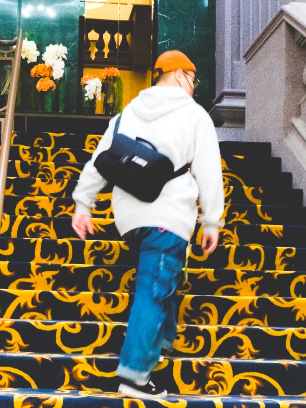 グレー系のトップス、ブルー系のパンツ、ブラック系のスニーカーを着用したメンズの冬コーディネートの4枚目の写真