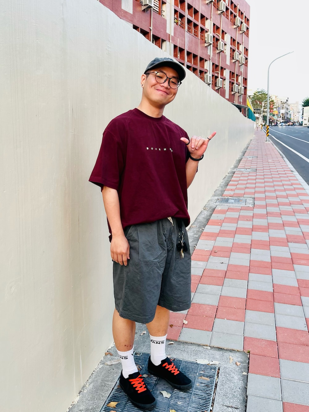 レッド系のトップス、グレー系のパンツ、ブラック系のシューズを着用したメンズの秋コーディネートの2枚目の写真