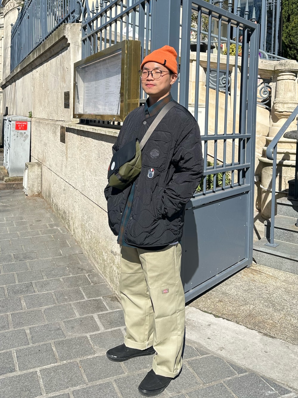 ブラック系のスニーカー、ベージュ系のパンツ、グリーン系のトップスを着用したメンズの春コーディネートの3枚目の写真