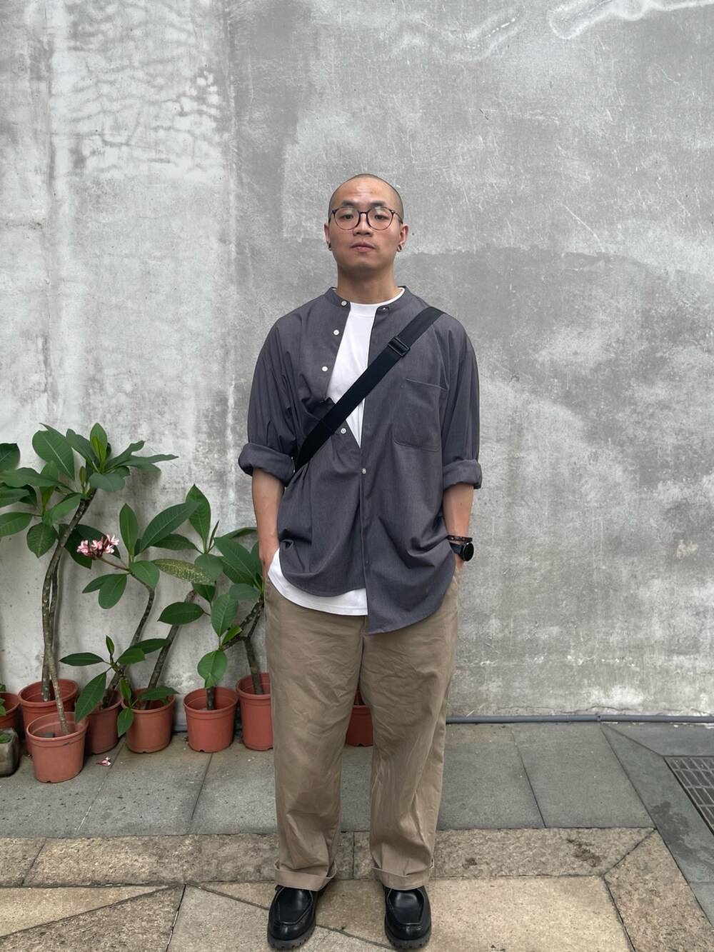 グレー系のトップス、ベージュ系のパンツ、ブラック系のシューズを着用したメンズの夏コーディネートの2枚目の写真