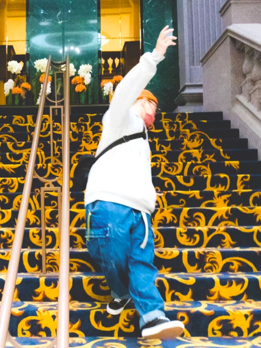 グレー系のトップス、ブルー系のパンツ、ブラック系のスニーカーを着用したメンズの冬コーディネートの3枚目の写真