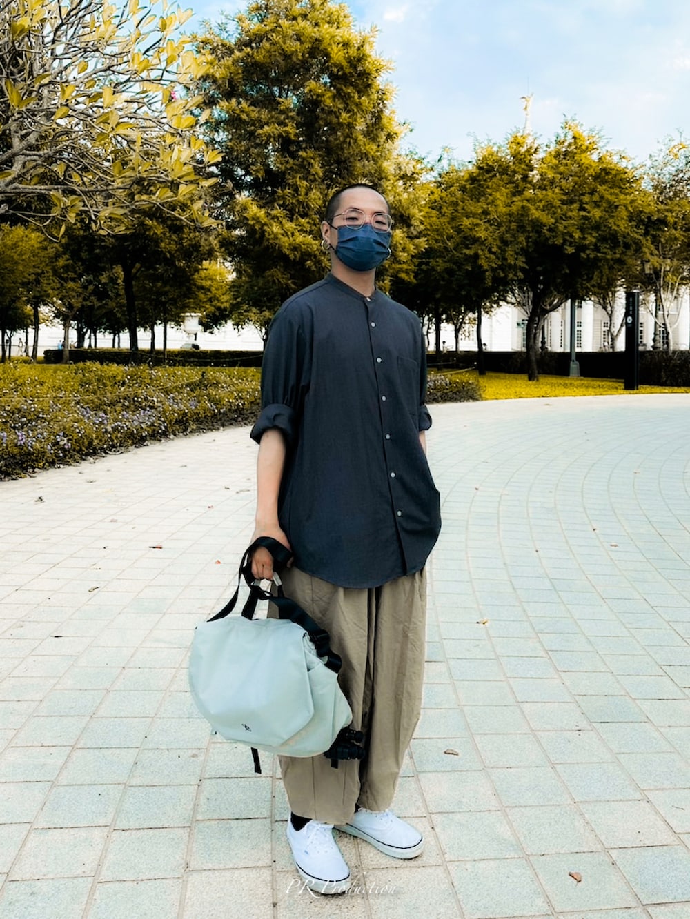 グレー系のトップス、ベージュ系のパンツ、ホワイト系のシューズを着用したメンズの秋コーディネートの2枚目の写真