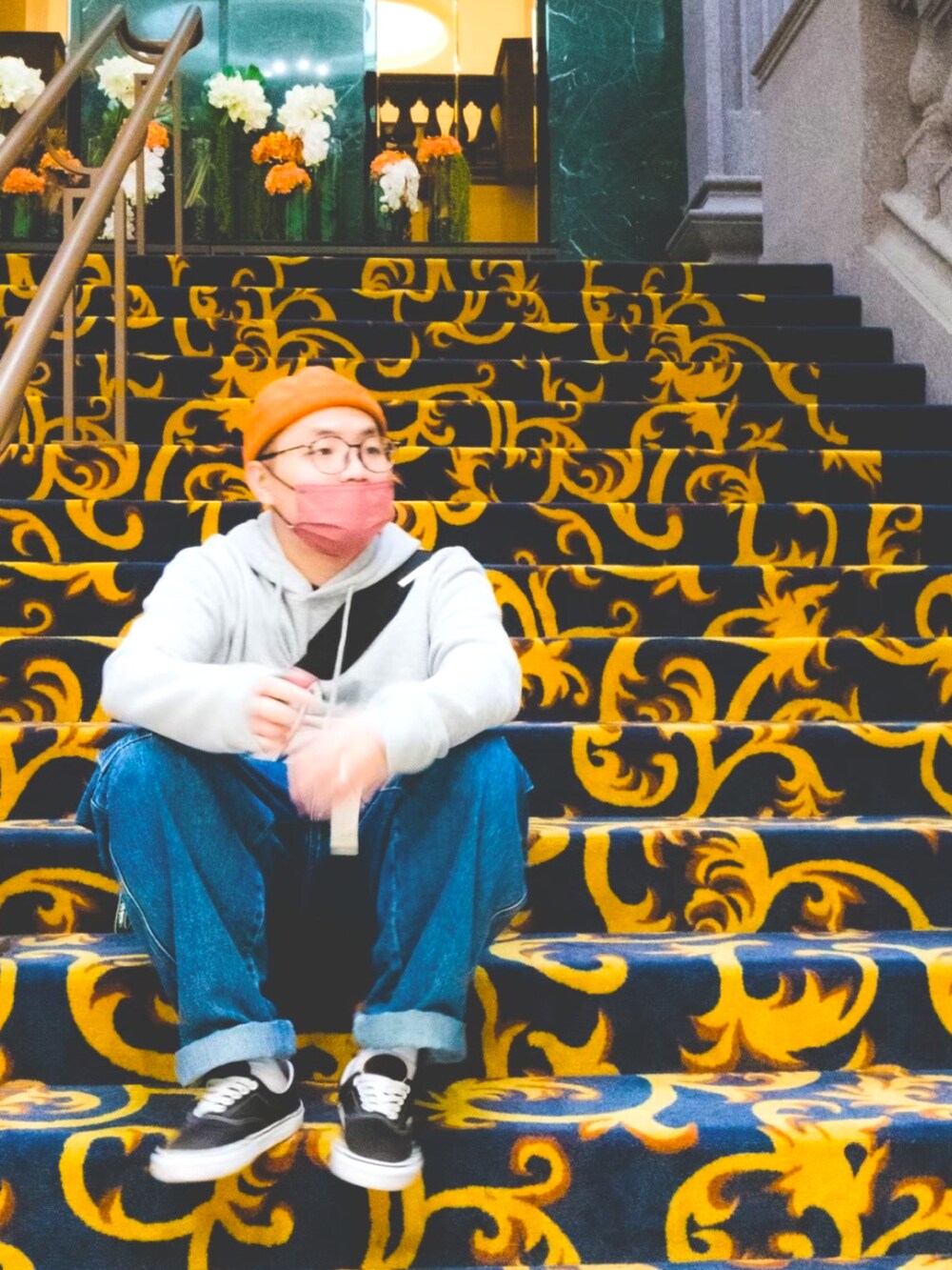 グレー系のトップス、ブルー系のパンツ、ブラック系のスニーカーを着用したメンズの冬コーディネートの2枚目の写真