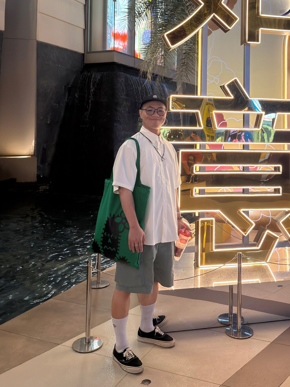 ホワイト系のトップス、グレー系のカーゴパンツ、ブラック系のスニーカーを着用したメンズの春コーディネートの3枚目の写真