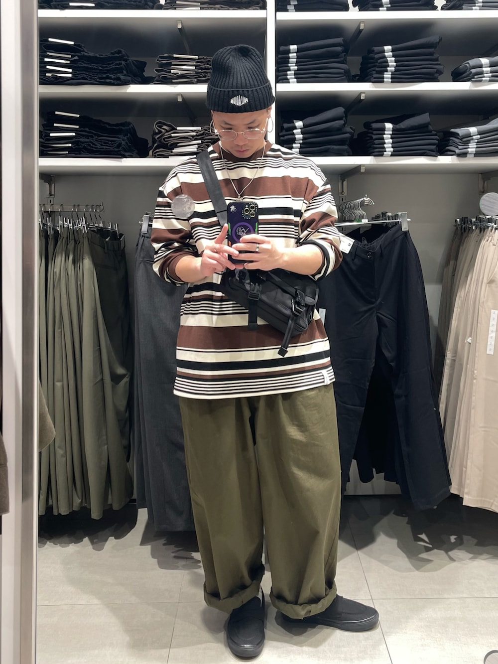 ブラック系のバッグ、グリーン系のパンツ、ブラック系のスニーカーを着用したメンズの冬コーディネートの2枚目の写真