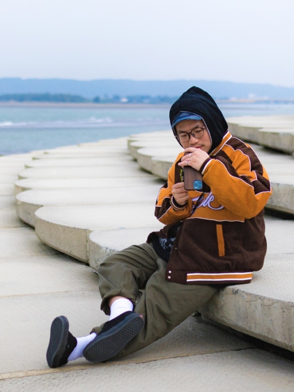 ブラック系のシューズ、グリーン系のパンツ、ブラック系のトップスを着用したメンズの冬コーディネートの2枚目の写真