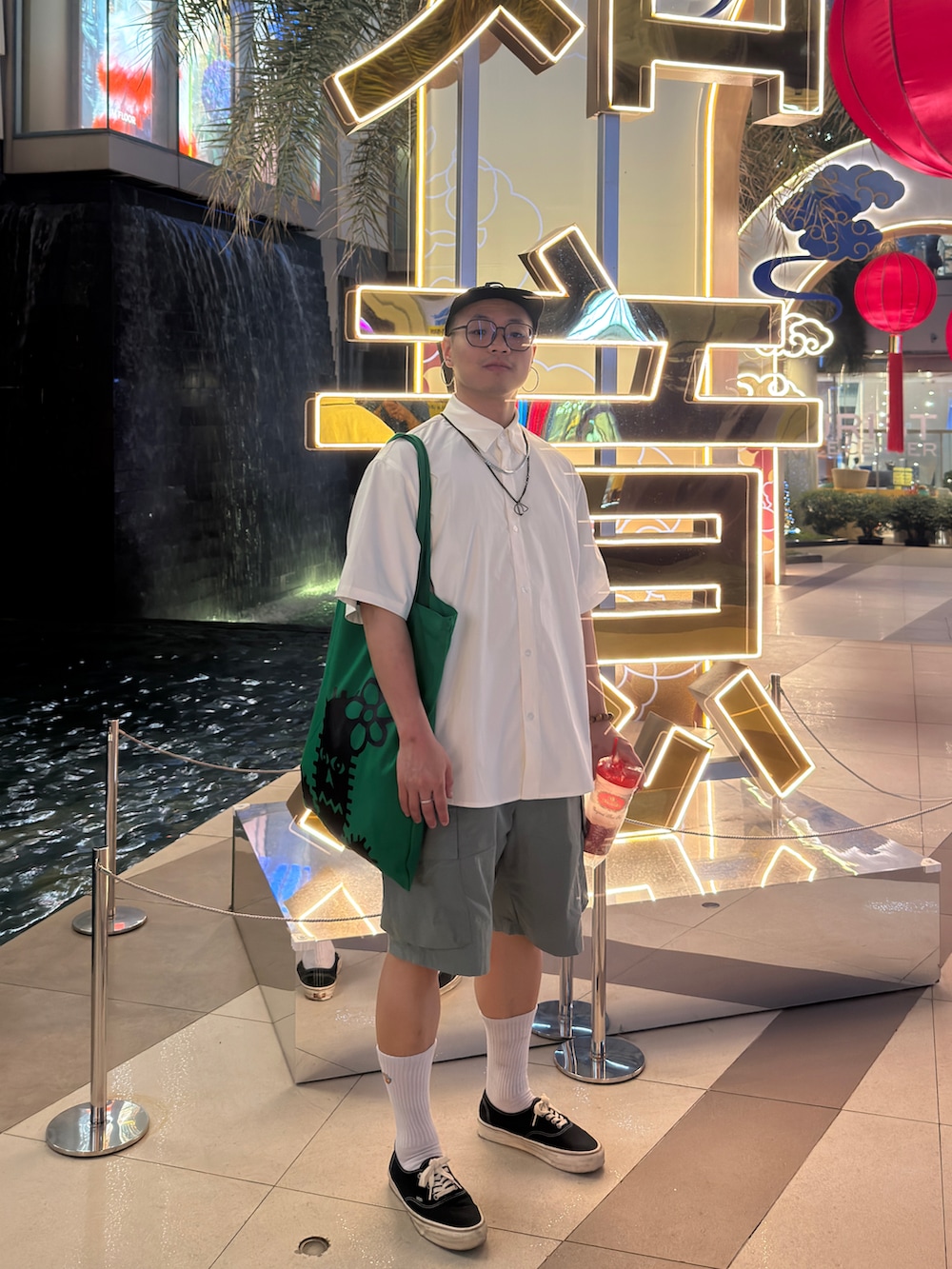 ホワイト系のトップス、グレー系のカーゴパンツ、ブラック系のスニーカーを着用したメンズの春コーディネートの2枚目の写真