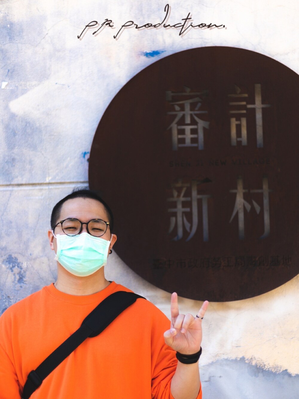 オレンジ系のトップス、グリーン系のチノパンツ、ブラック系のシューズを着用したメンズの冬コーディネートの3枚目の写真