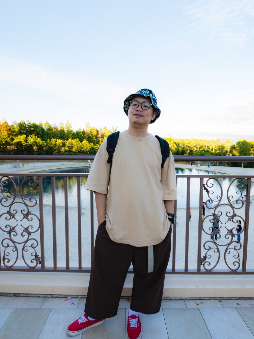 ブラック系のバックパック/リュック、ベージュ系のTシャツ/カットソー、ブラウン系のスラックスを着用したメンズの冬コーディネートの2枚目の写真