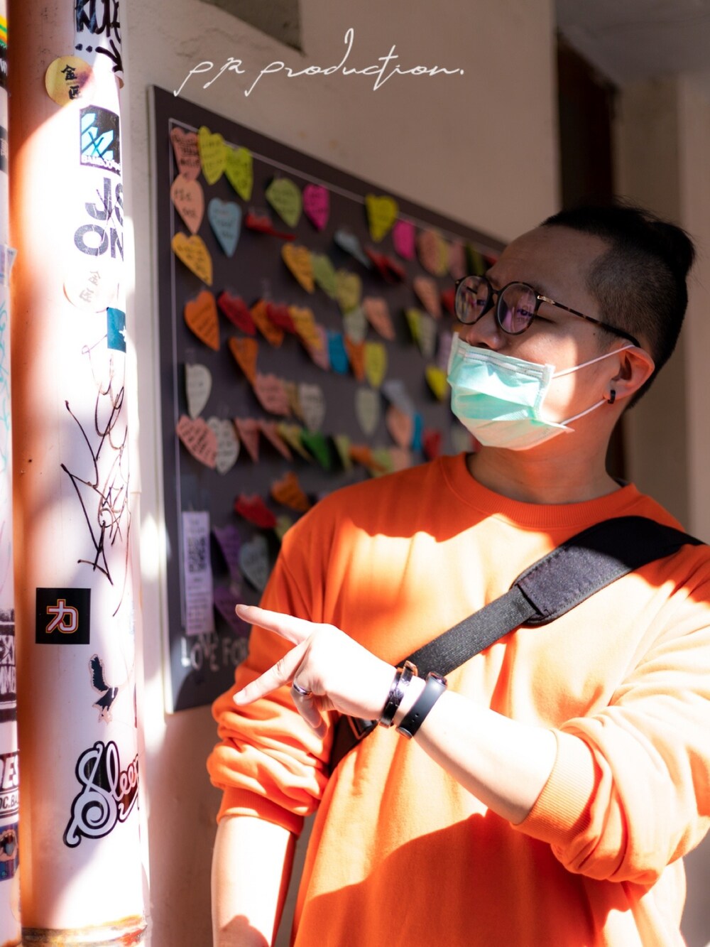 オレンジ系のトップス、グリーン系のチノパンツ、ブラック系のシューズを着用したメンズの冬コーディネートの2枚目の写真