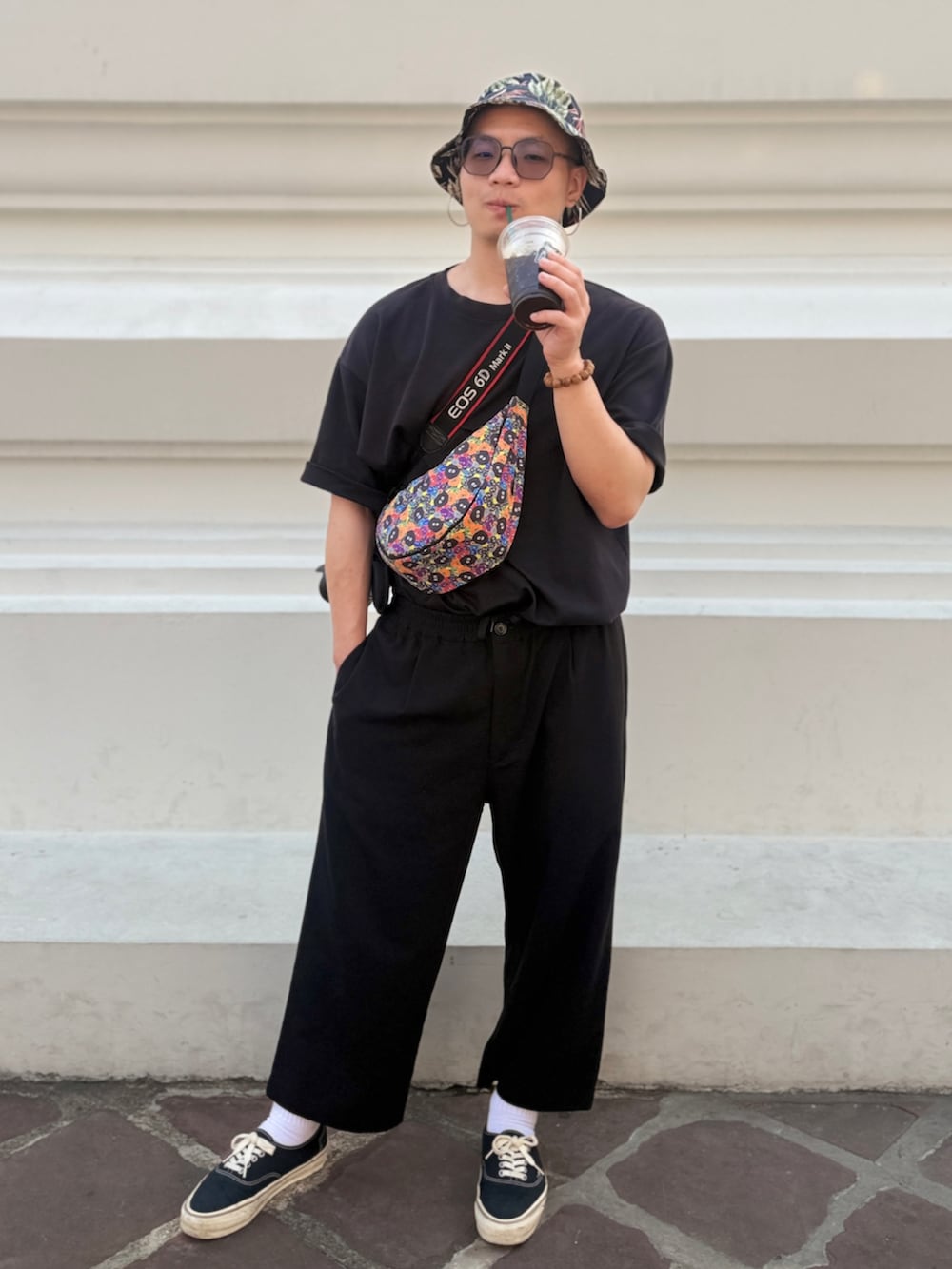 ブラック系のスラックス、ブラック系のトップス、ブラック系のスニーカーを着用したメンズの春コーディネートの2枚目の写真