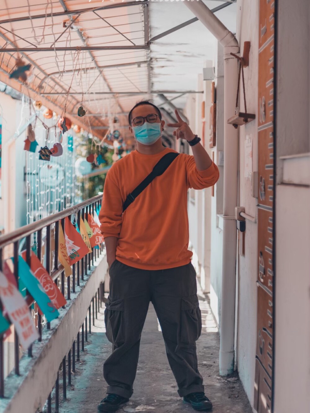 オレンジ系のトップス、グリーン系のチノパンツ、ブラック系のシューズを着用したメンズの冬コーディネートの4枚目の写真