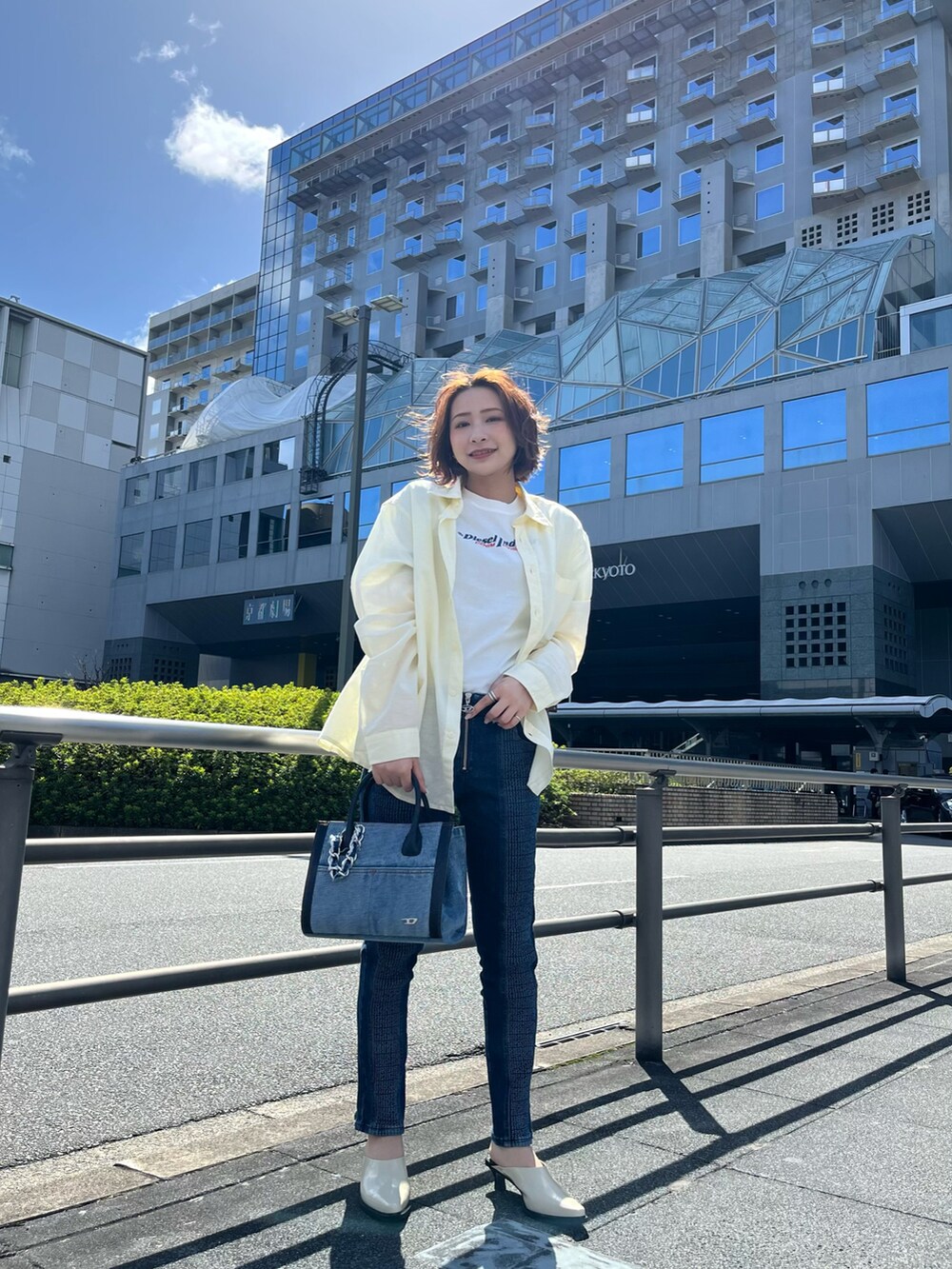 ホワイト系のシャツ/ブラウス、ホワイト系のTシャツ/カットソー、ブルー系のトートバッグを着用したレディースの春コーディネートの2枚目の写真