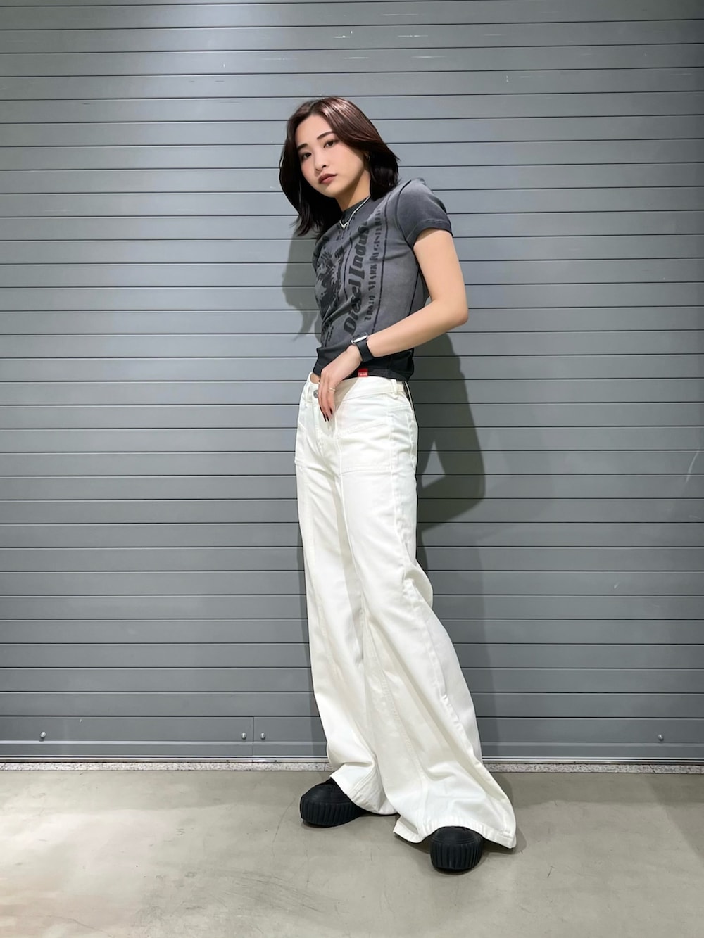 グレー系のTシャツ/カットソー、ホワイト系のデニムパンツ、ブラック系のスニーカーを着用したレディースの夏コーディネートの2枚目の写真