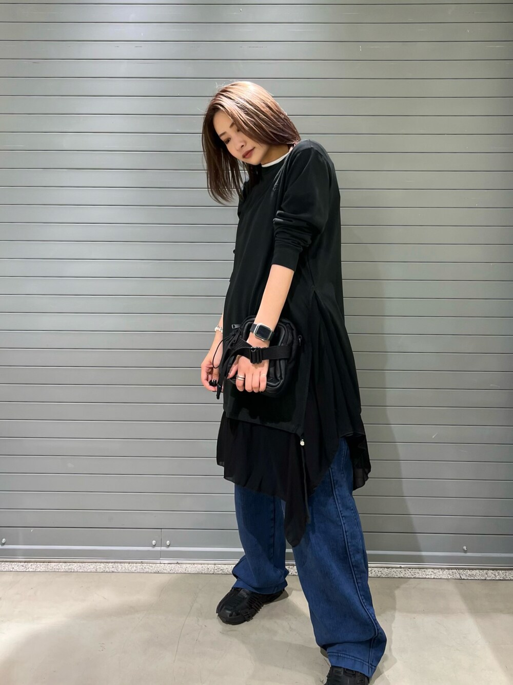 ブラック系のボディバッグ/ウエストポーチ、グリーン系のデニムパンツ、ブラック系のスニーカーを着用したレディースの秋コーディネートの2枚目の写真